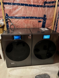 A washing machine and a drier installed and hooked up to the water supply