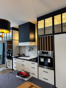 A wall oven and a microwave installed in two cabinets