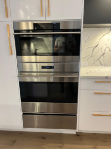 An installed Wolf wall oven and a microwave