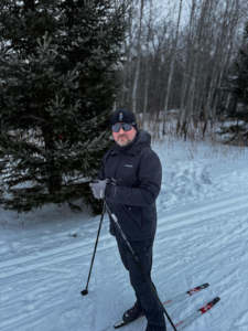 Victor, the founder of Lucky Wrench, on skis in a forest